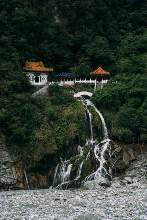 Changchun Shrine with water falling down rocks in Taroko National Park, Hualien Taiwan.の写真素材