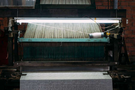 Close-up of old silk weaving machine running, creating silk cloth in Vietnam.の写真素材