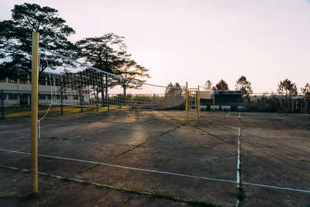 Old beat-up cement volleyball courts with yellow poles during sunset in Dalat, Vietnam.の写真素材