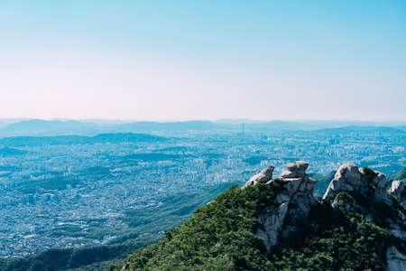 Mountain top in Bukhansan National Park, with city view of Seoul in background.