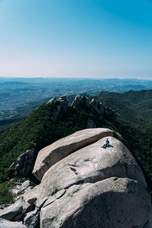 Hiker sitting alone on mountain top in Bukhansan National Park, Seoul, South Korea.の写真素材