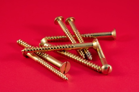 Brass wood screws against a red backgroundの写真素材
