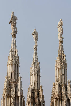 Close-up view of some spires and statues of the Duomo Cathedralの写真素材