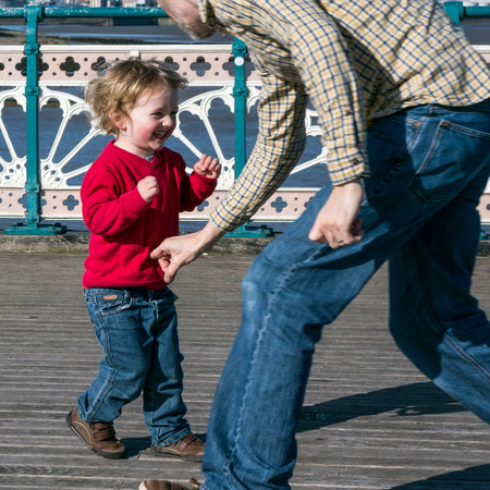 CARDIFF UK MARCH 2014 - Family playing on Penarth Pierのeditorial素材