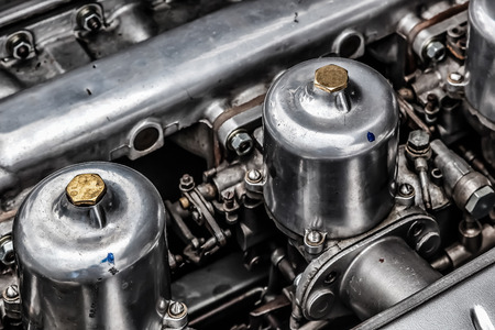 Carburettors under the bonnet of an old Jaguar sports car
