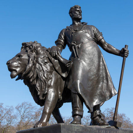 Statue of a man with lion at the Victoria Memorial outside Buckingham Palace in Londonのeditorial素材