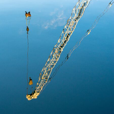 Reflection of a crane in a canal in Bruges West Flanders Belgiumの写真素材