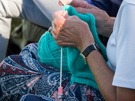 ISLE OF THORNS, SUSSEX/UK: Woman knitting at a Lawn Bowls Match at Isle of Thorns Chelwood Gate in SussexUnidentified womanの写真素材