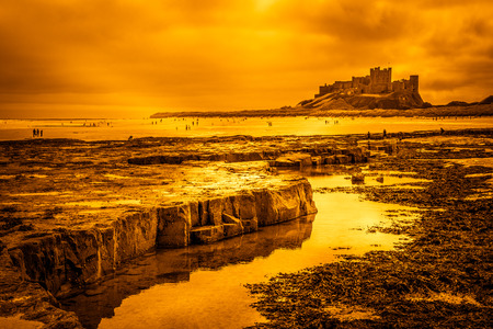 BAMBURGH, NORTHUMBERLAND/UK - AUGUST 15 : Shoreline view to Bamburgh Castle in Bamburgh Northumberland on August 15, 2010. Unidentified people.のeditorial素材