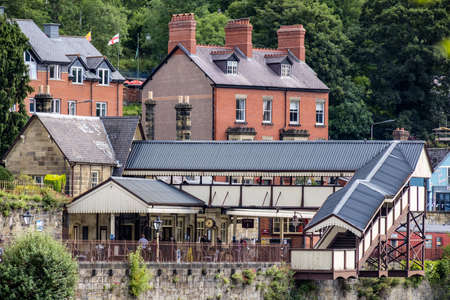 LLANGOLLEN, DENBIGHSHIRE, WALES - JULY 11 : View across the River Dee to the old station in LLangollen, Wales on July 11, 2021. Unidentified peopleのeditorial素材