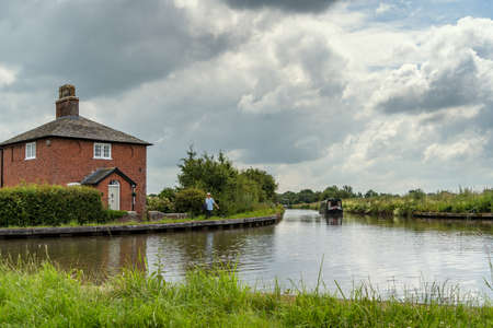 NEAR WHIXALL, SHROPSHIRE, UK - JULY 10 : Narrow boat on the Shropshire Union Canal in Shropshire on July 10, 2021. Three unidentified peopleのeditorial素材