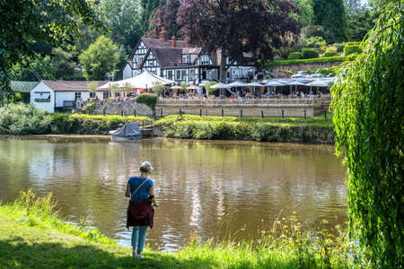 SHREWSBURY, SHROPSHIRE, UK - JULY 13 : Lady taking a photo by the River Severn in Shrewsbury, Shropshire, England, on July 13, 2021. Unidentified peopleのeditorial素材