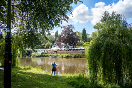 SHREWSBURY, SHROPSHIRE, UK - JULY 13 : Lady taking a photo by the River Severn in Shrewsbury, Shropshire, England, on July 13, 2021. Unidentified peopleのeditorial素材