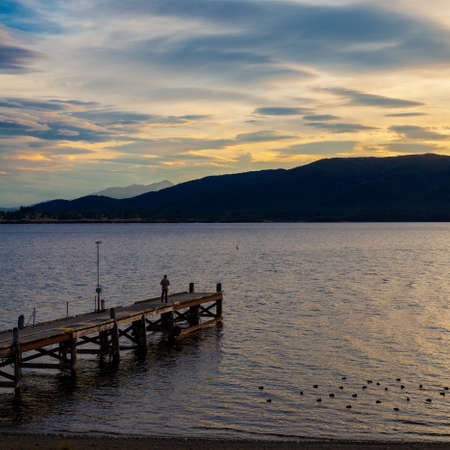 TE ANAU, FIORDLAND, NEW ZEALAND - FEBRUARY 17 : Admiring the Evening Sky at Te Anau, Fiordland, New Zealand on February 17, 2012. One unidentified personのeditorial素材