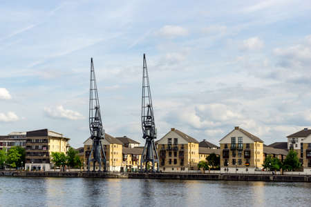 Old Dockside Cranes alongside a Waterfront Development  in London