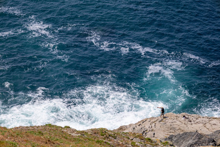 Trevose Head, Cornwall, UK - June 15.  Man fishing at Trevose Head in Cornwall on June 15, 2023. Unidentified manのeditorial素材