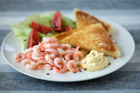 Shrimp sandwich on white plate with some vegetablesの写真素材