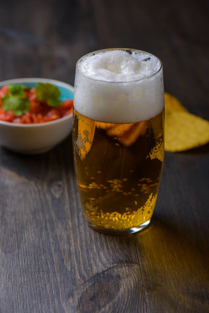 Beer with nachos and salsa in the backgroundの写真素材