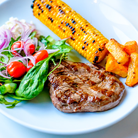 Grilled Beef Steak with some sallad on the side and cornの写真素材
