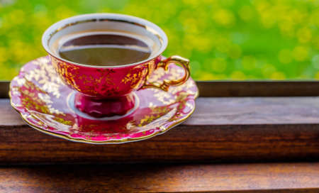 Coffee cup in window with green medow in the background relax from workの写真素材