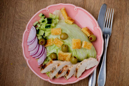 Chicken salad with tomatoes in the background on wood tableの写真素材