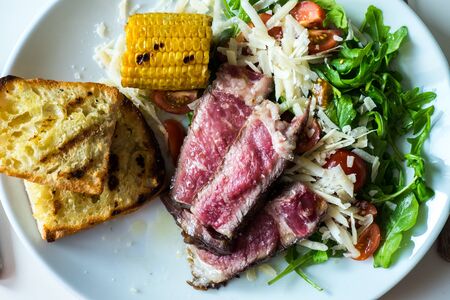 Mixed grill steak with corn and breadの写真素材