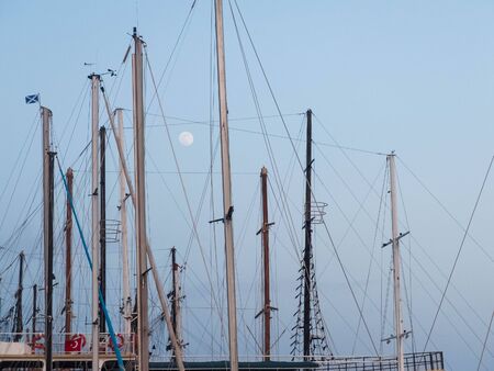 Full moon between masts of nautical vessels with Turkish and St.Andrew flag.の写真素材