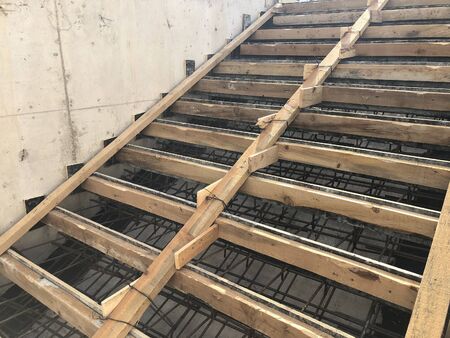 Metal reinforcement and wooden formworks of concrete stairway under construction.