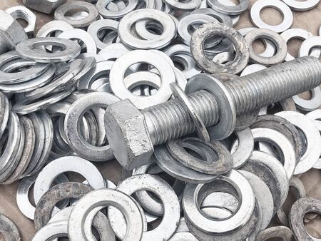 Steel nuts, bolts and washers piled in the box. Fastening construction equipment. Fixing hardware