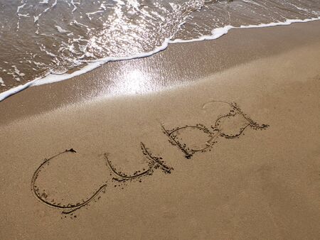 Inscription Cuba on the sandy beach and foamy sea water.の写真素材