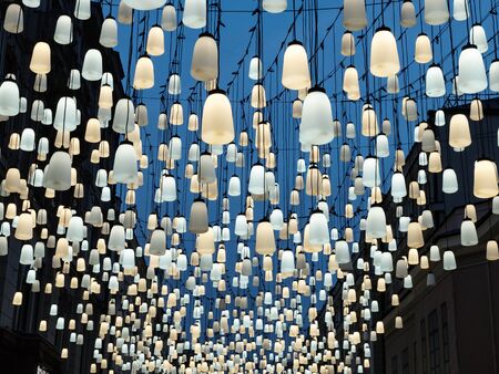 Beautiful bell-shaped lamps street illumination. Blue and yellow lanterns. Abstract background.の写真素材