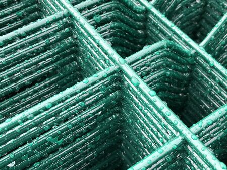 Rain drops on green colored metal grid.の写真素材
