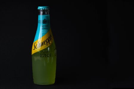 Mersin, Turkey - February 2020. Chilled bitter lemon Schweppes bottle with water drops and inscriptions on Turkish at black background.のeditorial素材