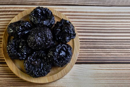 Dried prunes at weathered wooden background.の写真素材