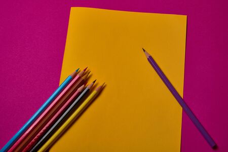 Multi colored crayons at yellow and magenta background with copy space.の写真素材