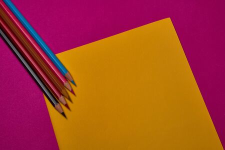 Multi colored crayons at yellow and magenta background with copy space.の写真素材