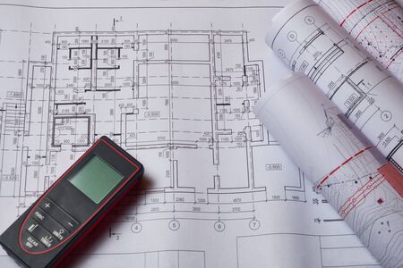 Laser meter and drawings at engineer workplace.