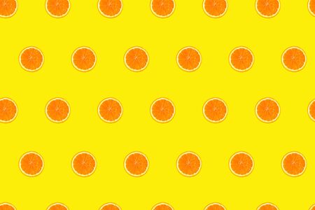 Cutted orange slices on yellow background seamless pattern