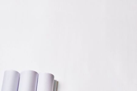 Rolled engineering drawings at white background with copy space.