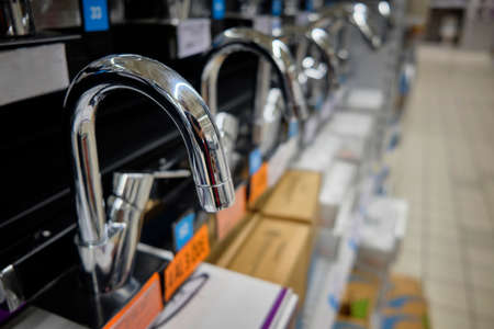 Row of brand new chrome colored water faucets.