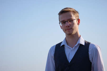 Young man with eyeglasses dressed in white shirt and waistcoat