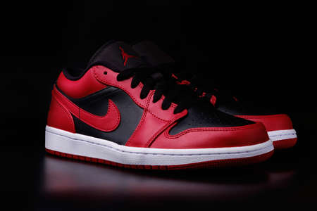 Nike Air Jordan 1 Retro Low Reverse Bred colorway sneakers on black background illustrative editorial.のeditorial素材