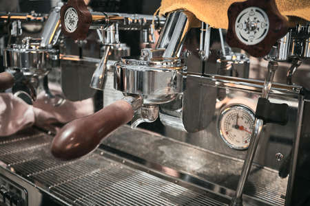 Close up of professional coffee machine. Brown handles and chrome surfaces of coffee machine.