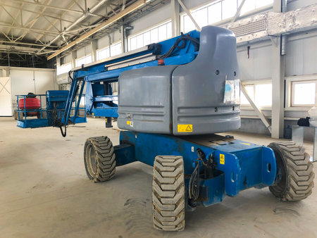 Manlifting vehicle inside industrial building. Man lifting platform machinery.