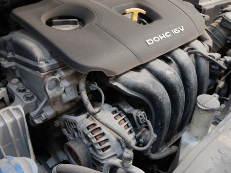Sixteen valve double overhead camshaft engine of korean car. Car with the open engine hood.