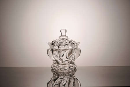 Empty glass bowl with a lid and its reflection on a grey backgroundの写真素材