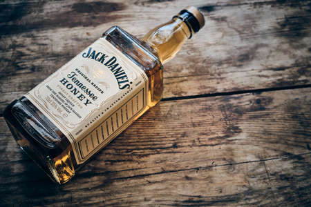 Jack Daniels Honey liqueur and apple fruit at weathered wooden backgroundのeditorial素材