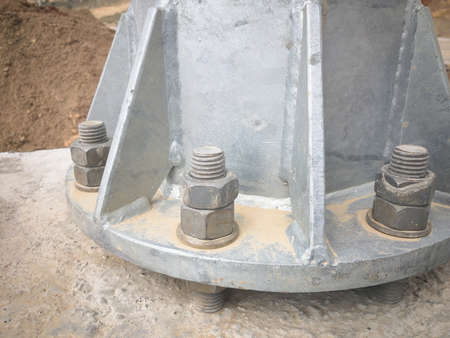 Metal pillar bolted to concrete foundation with anchor bolts