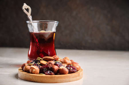 Turkish tea and nut mix at tableの写真素材