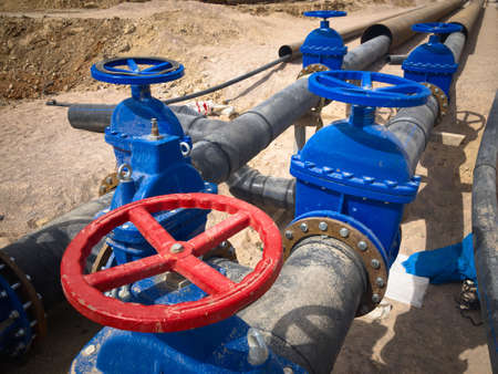 Valves on pipeline in ground. Pipe valves in trench